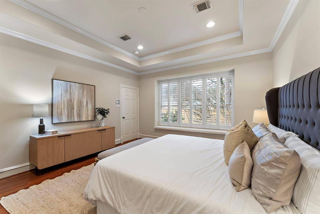 The spacious primary bedroom is brightened by an oversized window, offering tranquil views of the backyard.
