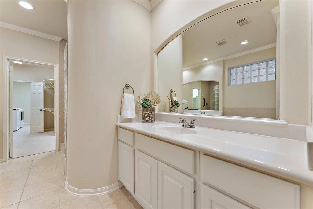 This spacious ensuite impresses with an expansive vanity area and ample cabinetry, thoughtfully designed for effortless daily routines.