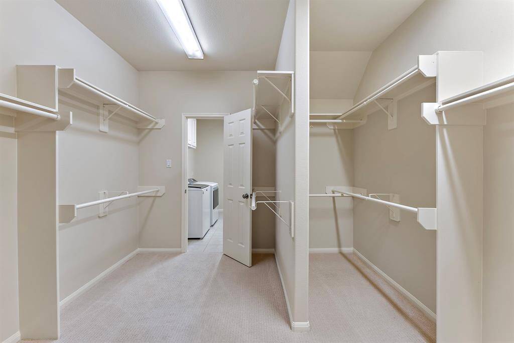 Find abundant storage and built-in racks in this spacious walk-in closet, directly connected to the dedicated utility room.