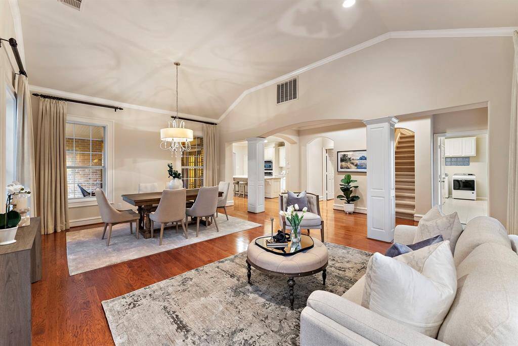 In this inviting living and dining space, abundant natural light streams through expansive windows, complemented by a spacious open layout.