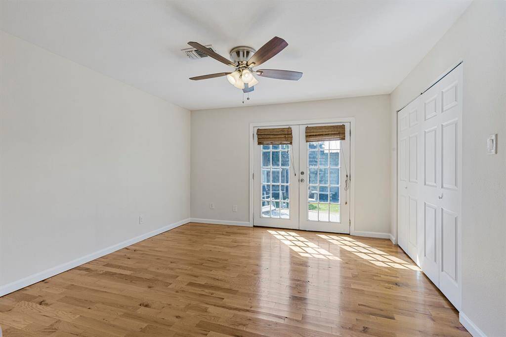 French doors lead out to wood deck off of the primary bedroom