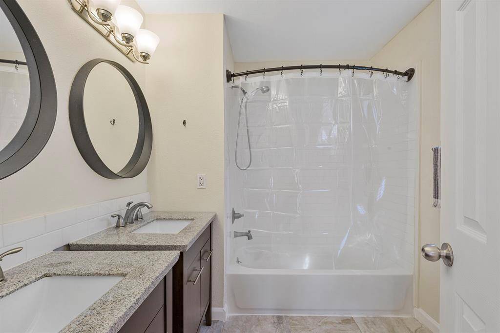 Luxurious primary bathroom with double sinks and a convenient tub-shower combo.