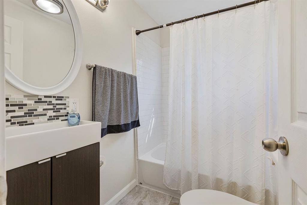 Convenient full bathroom located off the hallway, adjacent to the second bedroom.