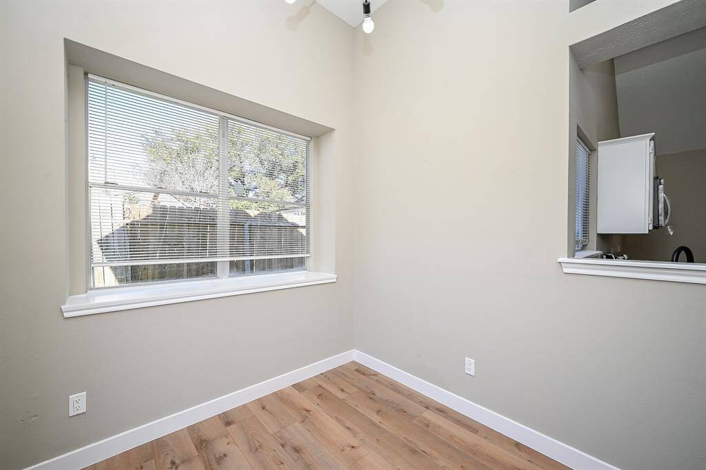 Natural light fills the room, highlighting the warm-toned, wide plank flooring.