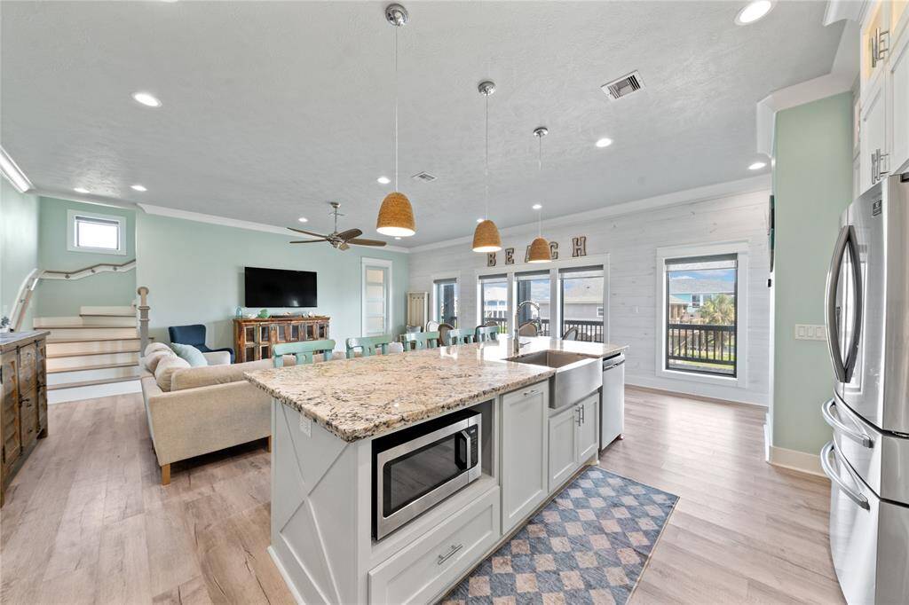 The spacious, open kitchen is the heart of this home, featuring sleek quartz countertops, stainless steel appliances, and a large island with seating. Perfect for entertaining, this modern kitchen seamlessly connects to the dining and living areas, making hosting a breeze.