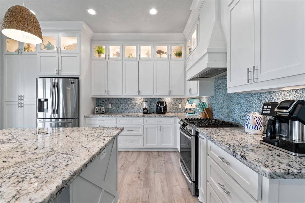 Gleaming quartz countertops extend throughout the kitchen, providing tons of workspace for cooking and entertaining.