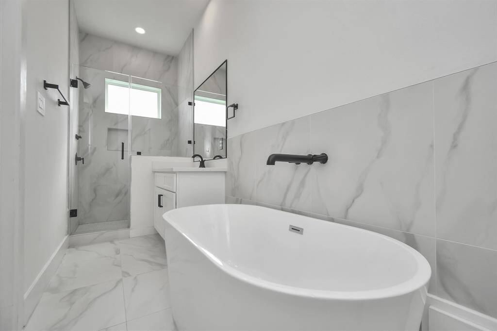 Another view of the luxury that is the primary bath, highlighted the two beautifully appointed vanity areas, spacious soaking tub and walk in closet