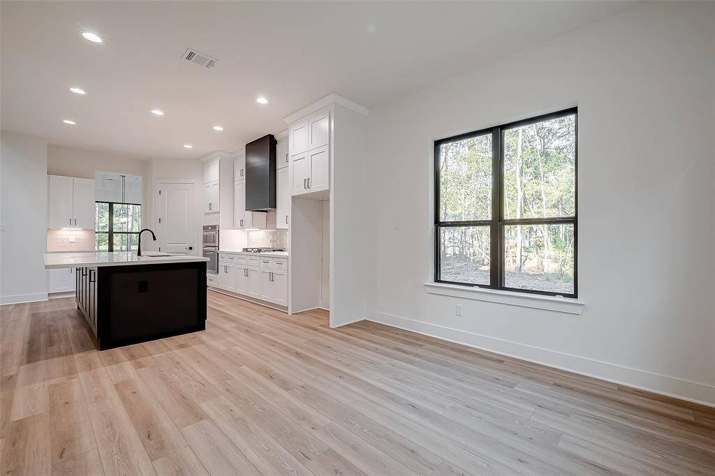 Recessed lighting in the kitchen with windows providing natural light to the breakfast nook