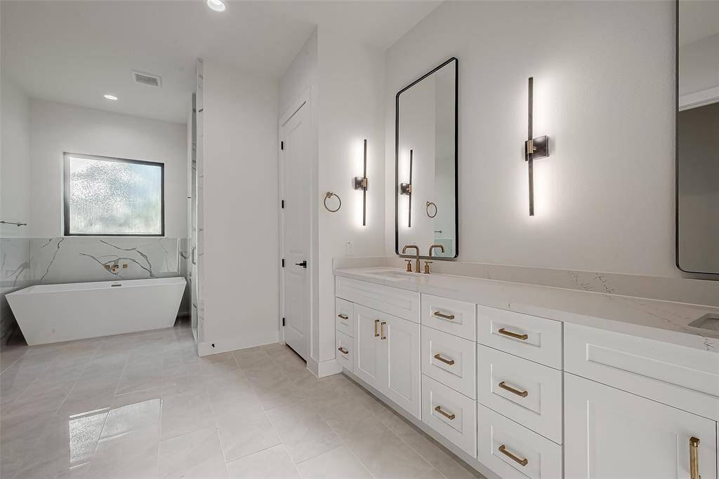 The closet entrance is between the soaking tub and double sinks