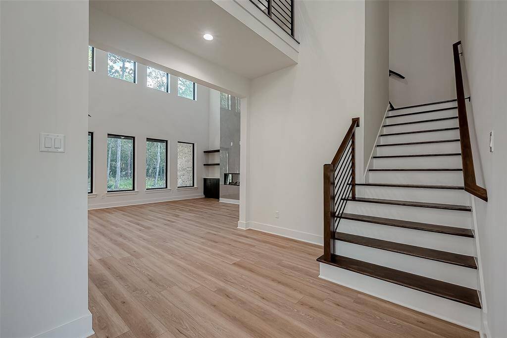 Stairway with recessed lighting underneath the upstairs walkway