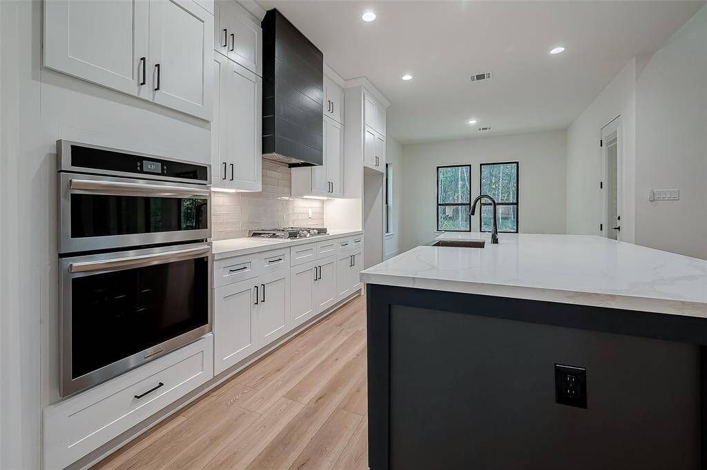 The kitchen features undercabinet lighting with subway tile