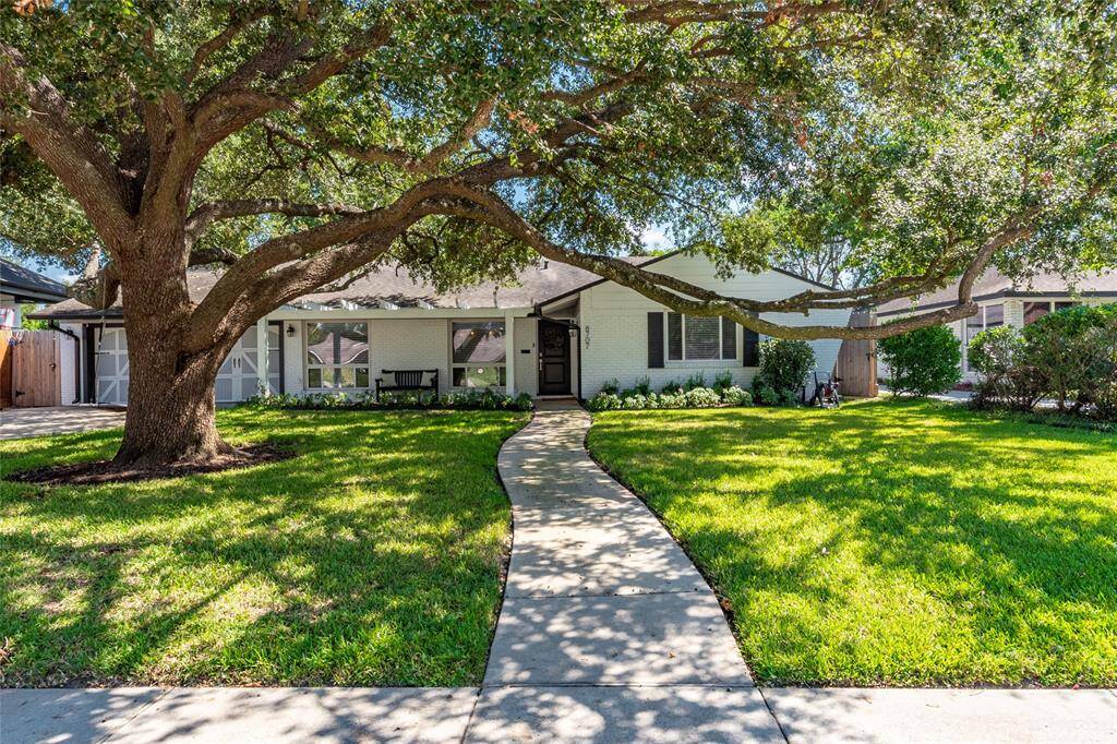 Charming single-story home with a welcoming facade, featuring a large, shady oak tree in the front yard. A curved walkway leads to the entrance, surrounded by a well-maintained lawn and landscaping. Ideal for buyers seeking a cozy, inviting property.