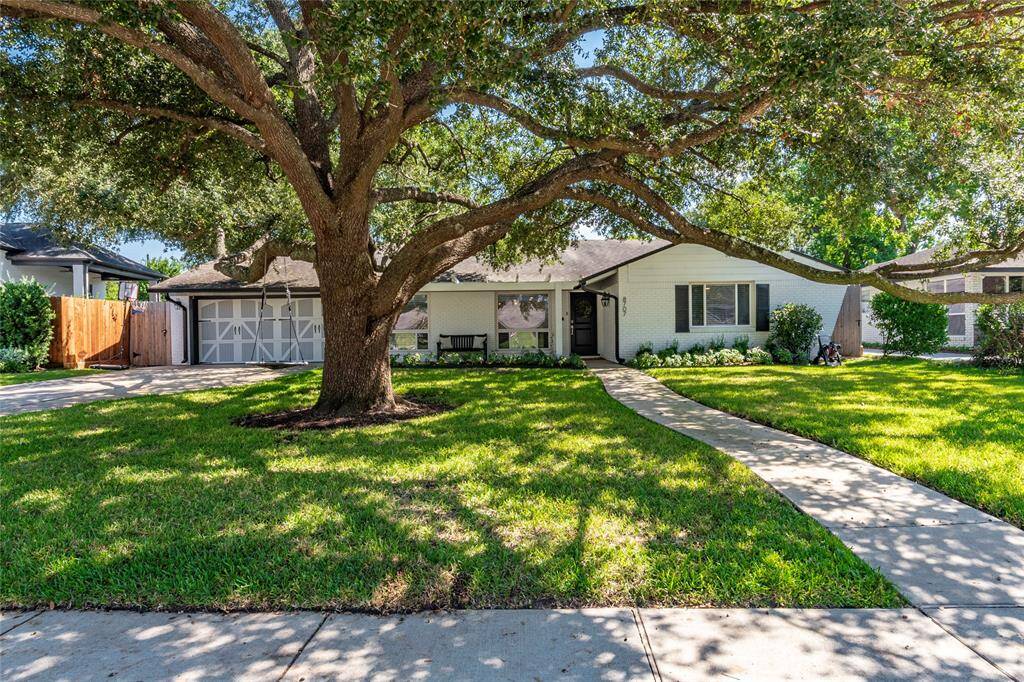 Charming single-story home with a welcoming facade, featuring a large, shady tree in the front yard. A curved walkway leads to the entrance, surrounded by a well-maintained lawn and landscaping. Ideal for buyers seeking a cozy, inviting property.