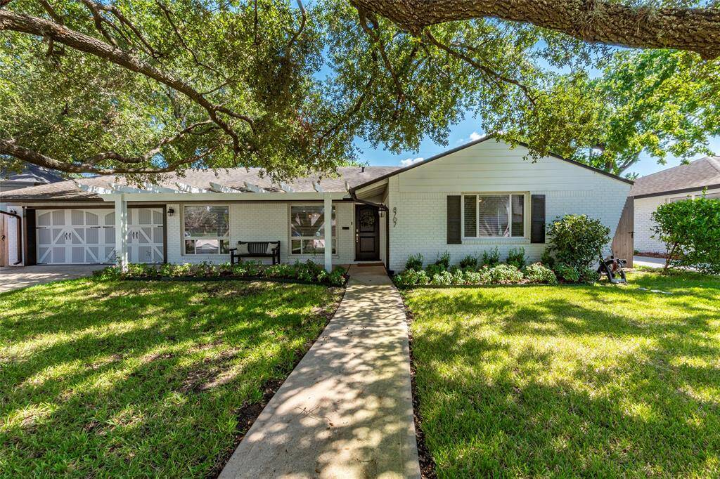 Charming single-story home with a welcoming facade, featuring a large, shady tree in the front yard. A curved walkway leads to the entrance, surrounded by a well-maintained lawn and landscaping. Ideal for buyers seeking a cozy, inviting property.