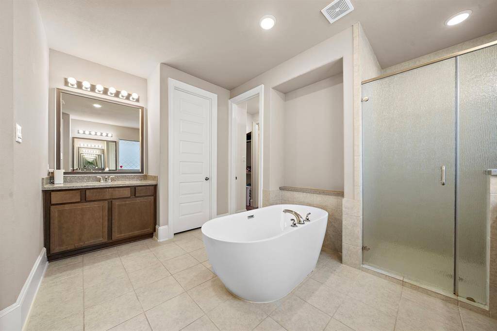 Second view of Primary ensuite bathroom with soaking tub and separate walk in shower and dual vanities