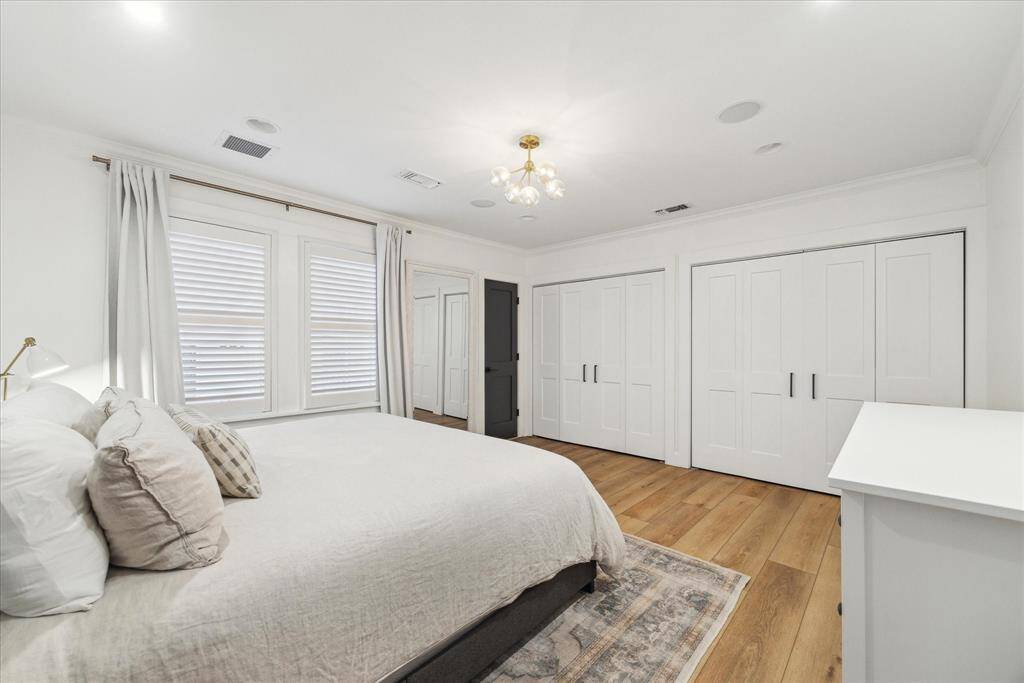 Primary suite w/ new light fixture, updated bedroom & closet doors, & fresh interior touches.