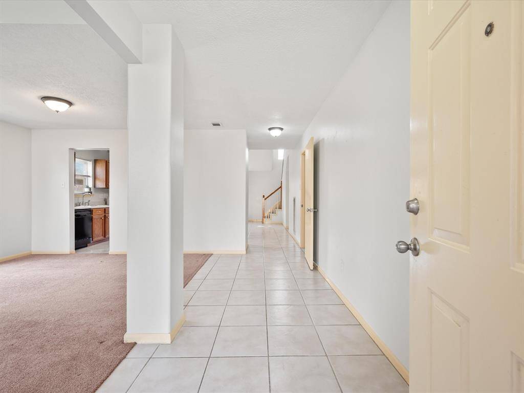 Bright entryway with tiled flooring leads to an open living and dining space.
