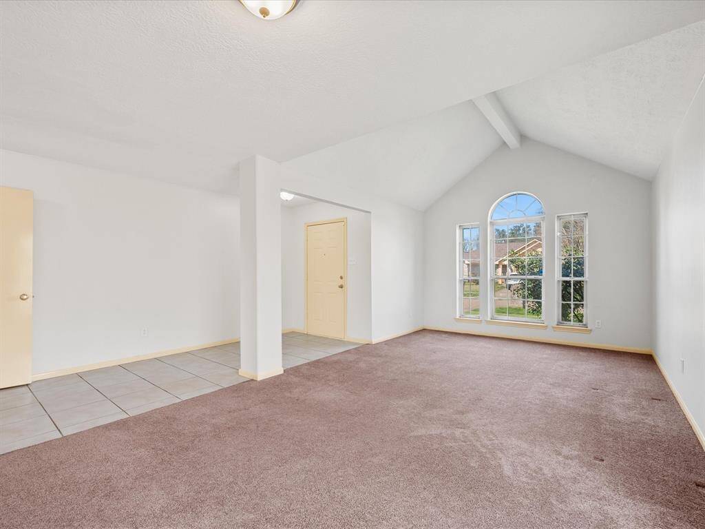 The living and dining room features vaulted ceilings and large arched windows, providing plenty of natural light.