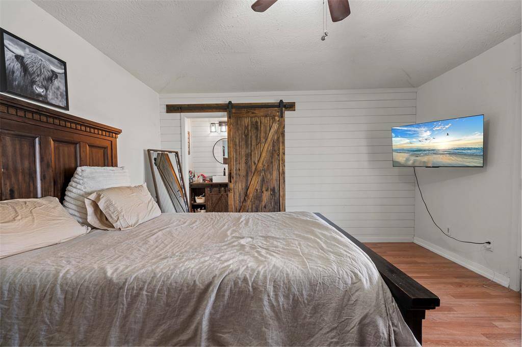 Primary bedroom with accent wall and barn door
