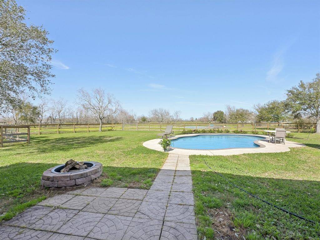 The backyard has a fire pit and is just steps from the pool.