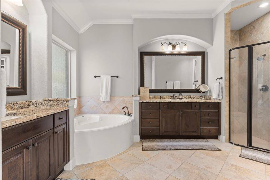 Ensuite bath features 2 separate vanities as well as a jetted soaking tub, walk in shower, and walk in closet.