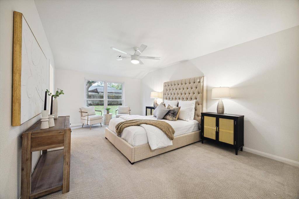 THE PRIMARY SUITE FEATURES PLUSH "ZOEY" CARPET AND SERENE VIEWS OF THE BACKYARD.