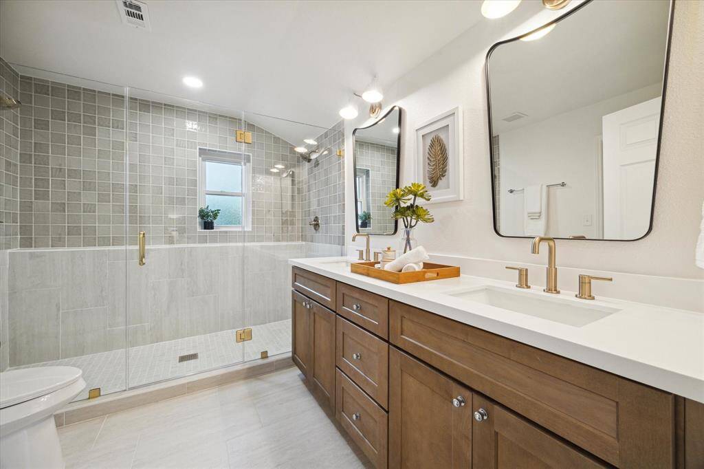 THE ENSUITE HAS DESIGNER PICKED KARMEL CABINETS, PURE WHITE QUARTZ COUNTER AND DOUBLE SINKS. MIRRORS AND FIXTURES ARE BOTH MODERN AND CHIC. WOW - LOOK AT THAT HUGE OVER-SIZED SHOWER WITH SEEMLESS GLASS AND FLOOR TO CEILING TILES.