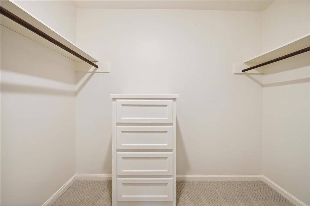 SPACIOUS WALK-IN CLOSET WITH RAILS, SHELVES AND CABINET FOR EASY ORGANIZING.