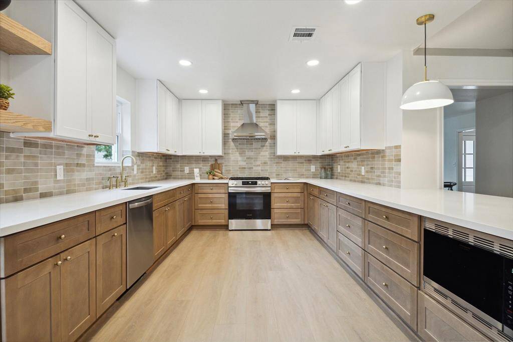 THE KITCHEN IS BEAUTIFULLY UPDATED WITH MIXED KARMEL AND WHITE SHAKER CABINETS, PURE WHITE QUARTZ COUNTERS AND COORDINATED SUBWAY BACK-SPLASH.