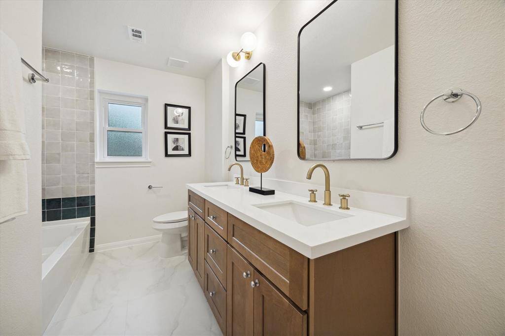 UPDATED SECONDARY BATHROOM WITH DOUBLE SINKS, KARMEL CABINETS AND MORE PURE WHITE QUARTZ COUNTERS.