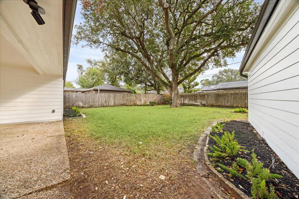 THE BACKYARD FEATURES SPACIOUS LAWN AND RECENT LANDSCAPING.