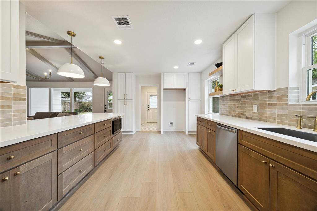 THE KITCHEN IS WELL EQUIPPED WITH STAINLESS STEEL APPLIANCES, DEEP UNDER-MOUNT SINK AND CHIC PENDANT LIGHTING.