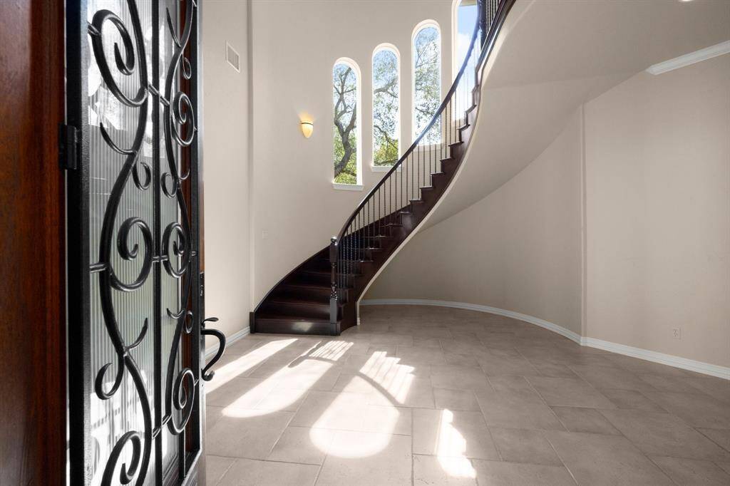 An elegant entryway welcomes you with a grand staircase and abundant natural light.