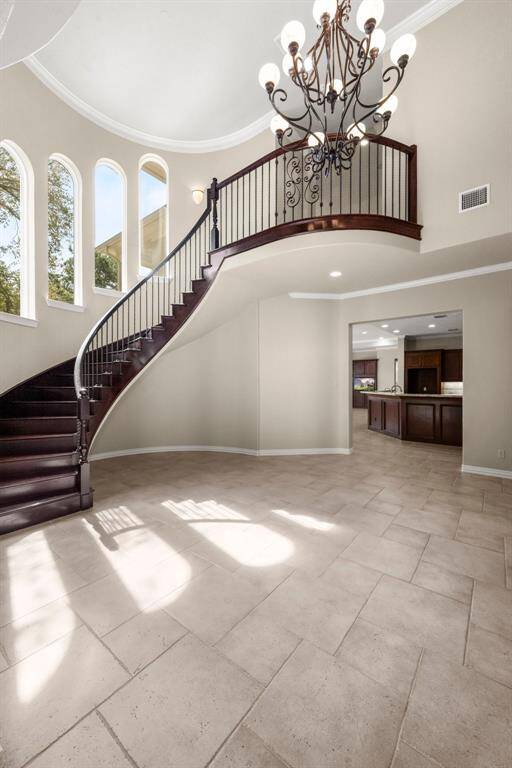 Elegant curved staircase enhances this home's grand entrance, offering a touch of sophistication and style.