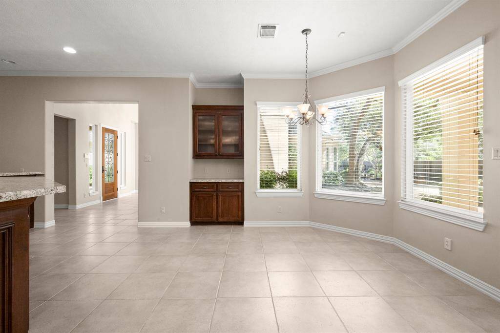 Bright and inviting breakfast nook with large windows and elegant lighting, perfect for morning coffee.