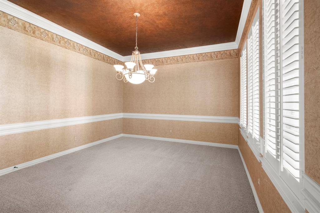 Elegant formal dining room with large windows, rich textures, and a stylish chandelier—perfect for hosting memorable gatherings.