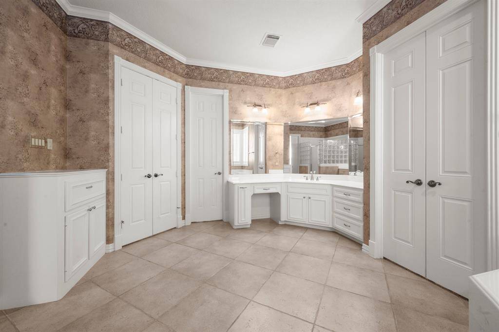 Elegant primary bathroom featuring spacious dual vanities, ample storage, and sophisticated design.