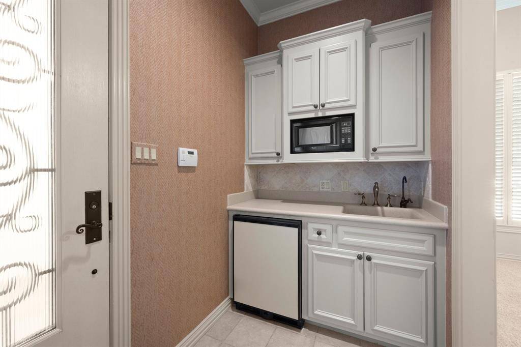 The casita is separate from the main home and offers a cozy kitchenette with off-white cabinetry, a built-in microwave, small sink and mini-fridge.