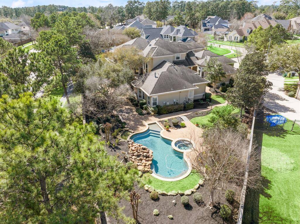 Stunning aerial view of a beautifully landscaped backyard featuring a sparkling pool, perfect for relaxation and entertainment.