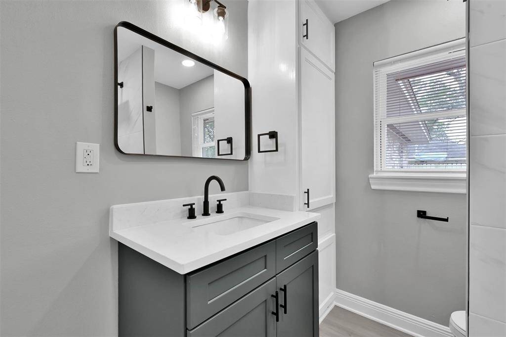 Secondary bathroom also features floor to ceiling cabinetry and updated finishes.