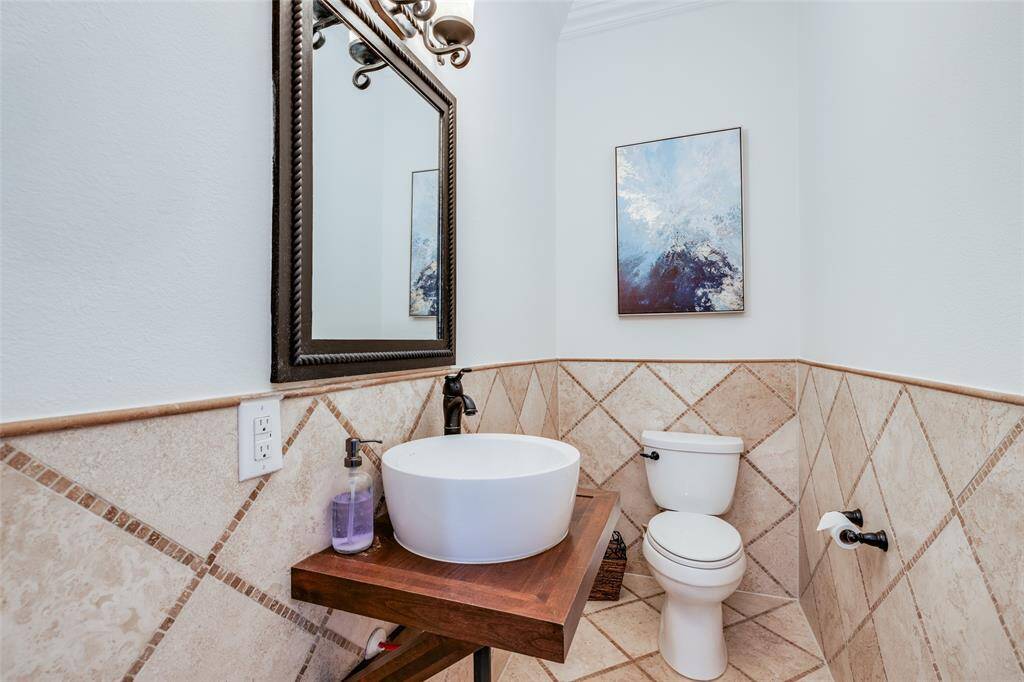 Spacious First floor half bathroom with lots of beautiful travertine tile, oil rubbed bronze fixtures & mirror