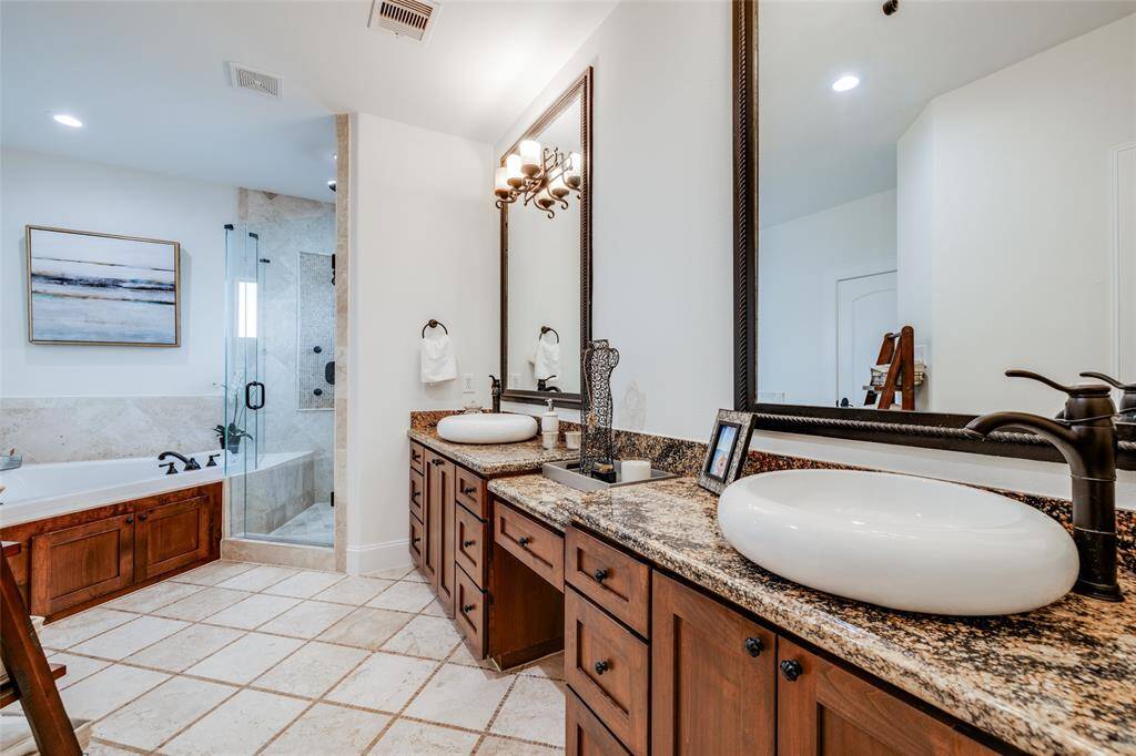 Huge Primary bathroom with corner jacuzzi bath, shower with seamless glass and window for lots of natural light, large mirrors, dual vanities, oil rubbed bronze fittings