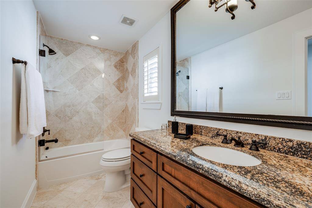 Bathroom 3  on 3rd floor with beautiful travertine tile, seamless glass shower door, oil rubbed bronze fittings, large mirror, granite counters, beautiful wooden cabinets, window for lots of natural light