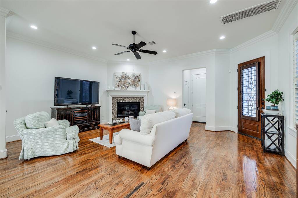 First floor Living Room with ceiling fan, crown molding, oak hardwood floors, doors through to attached garage
