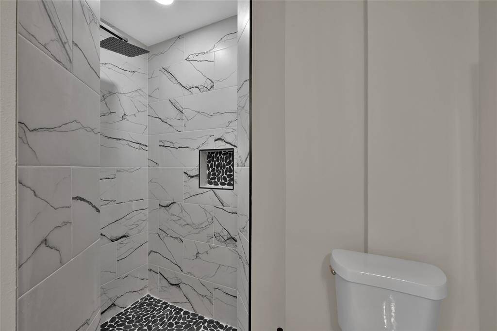 Luxury finishes such as the rain shower head help elevate this bathroom.