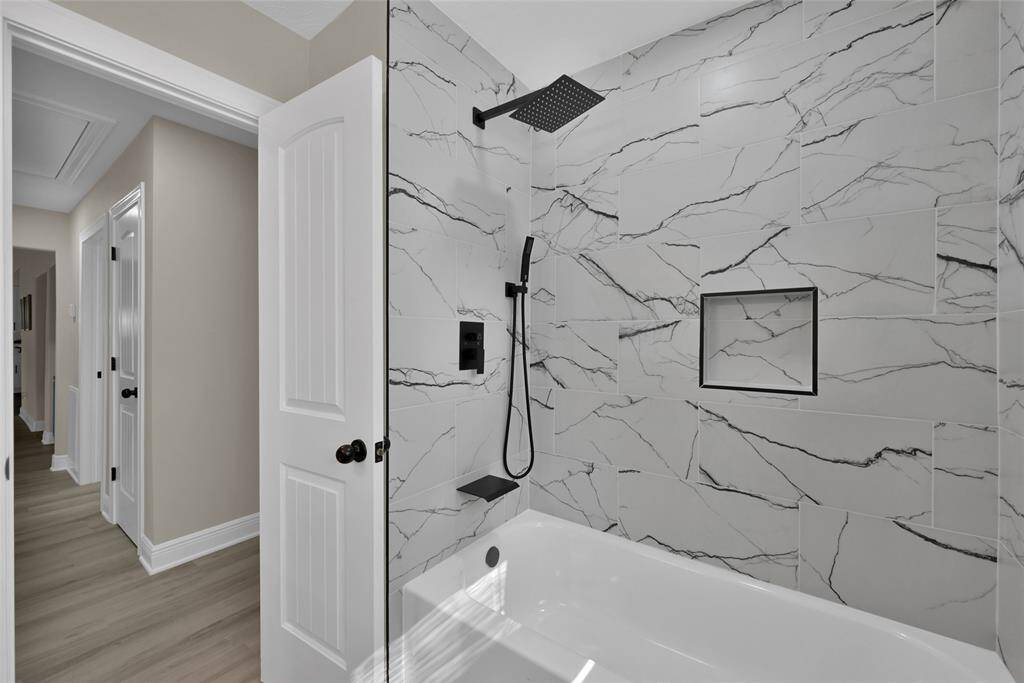 The sleek and modern style continues throughout the home. The secondary bath features a shower/tub combo.