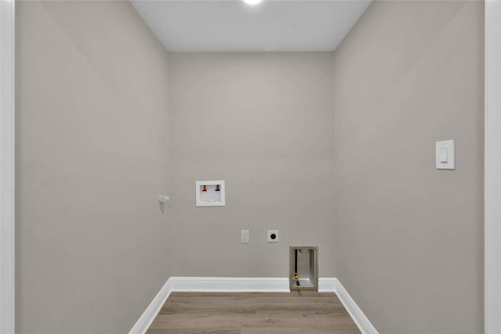 The simple and clean laundry room features gas and electric dryer connections.