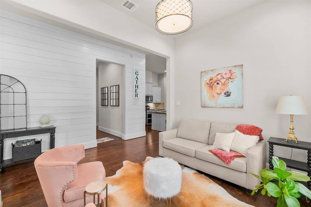 Sitting area with a glimpse into the adjacent kitchen offers a peek at modern amenities.