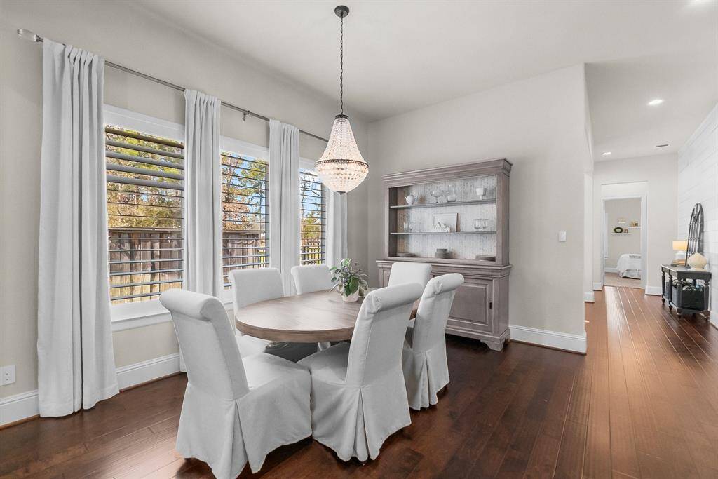 Elegant dining area with stylish chandelier and windows for natural light.