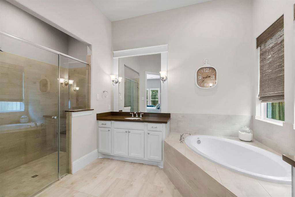 Large walk-in shower and beautiful light hardwood flooring in primary bathroom.